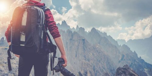 望遠レンズを持つ男性と山